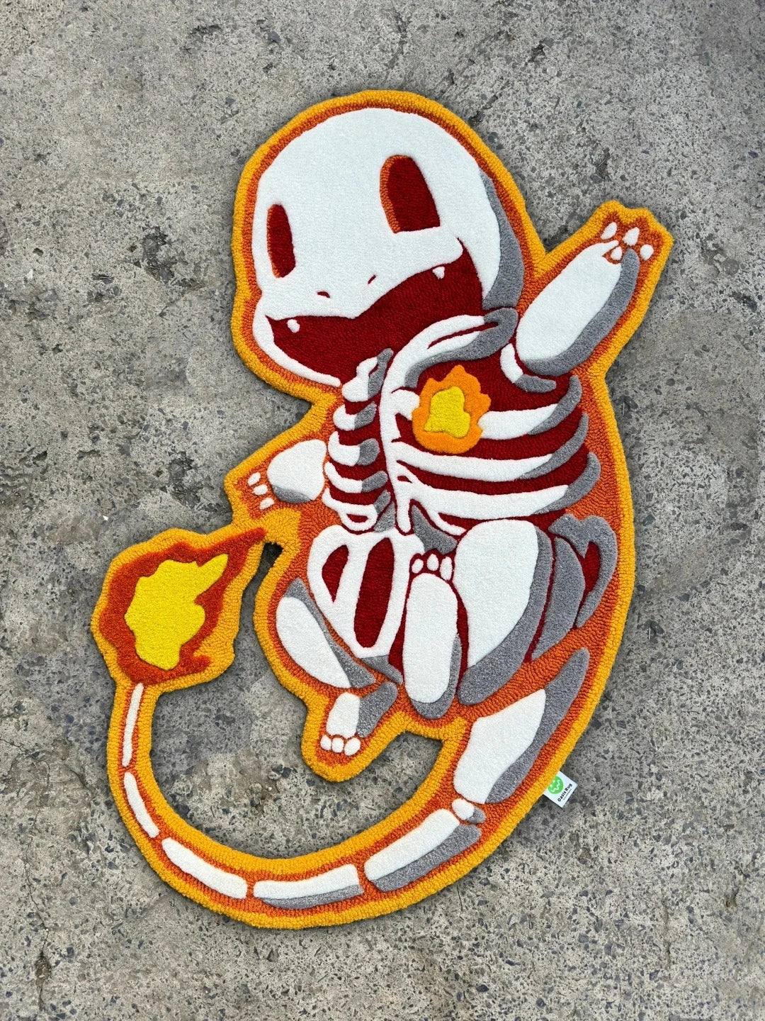 Full front view of the handmade flame-heart lizard tufted rug featuring a cute reptile character with a heart-shaped flame motif, showing the overall shape, colors, and finished pile texture.