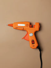 Compact mini hot glue gun for tufting finishing and craft projects, shown alone with ergonomic handle and precision nozzle.