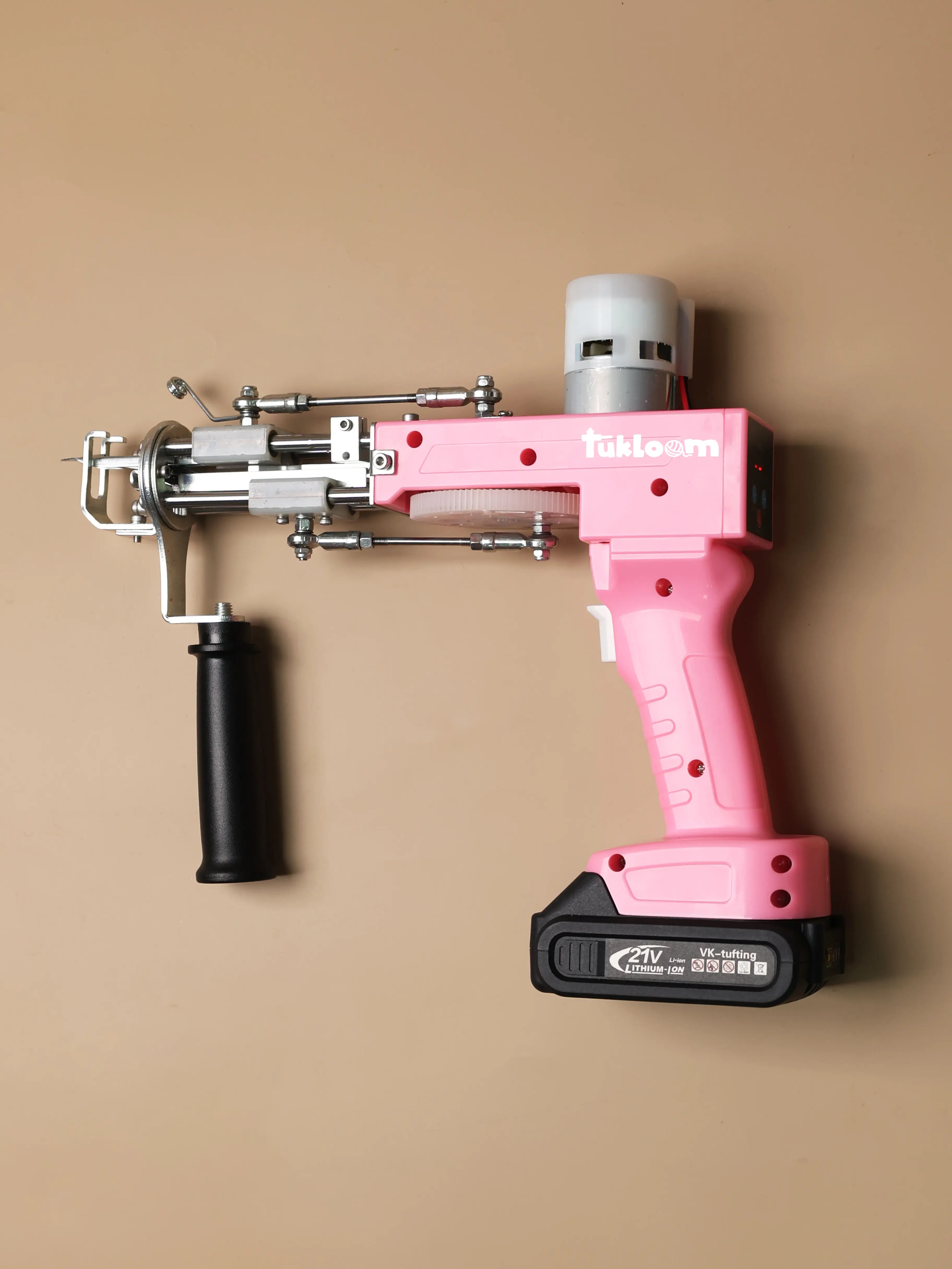 Close-up of cordless tufting gun with digital speed display and battery pack, designed for portable rug tufting projects