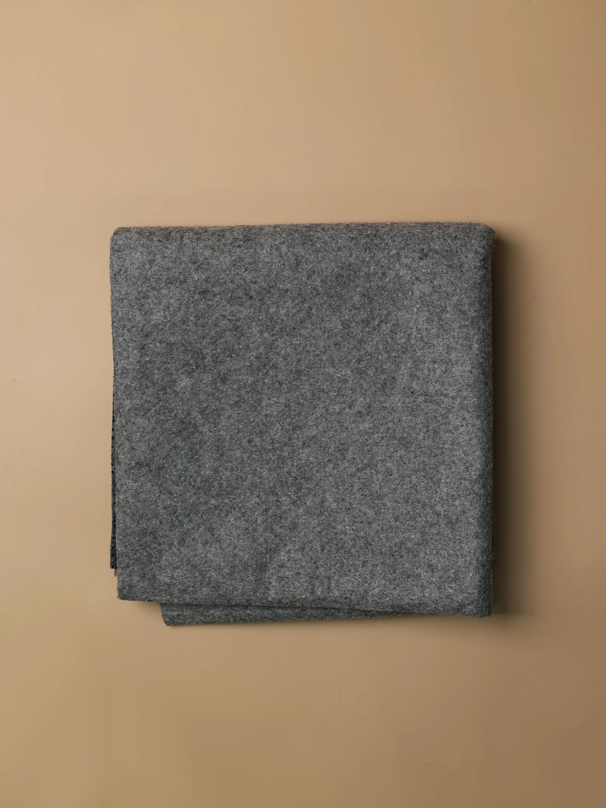 Front view of dark gray tufting backing cloth showing its reinforced grid texture designed to support primary tufting cloth.