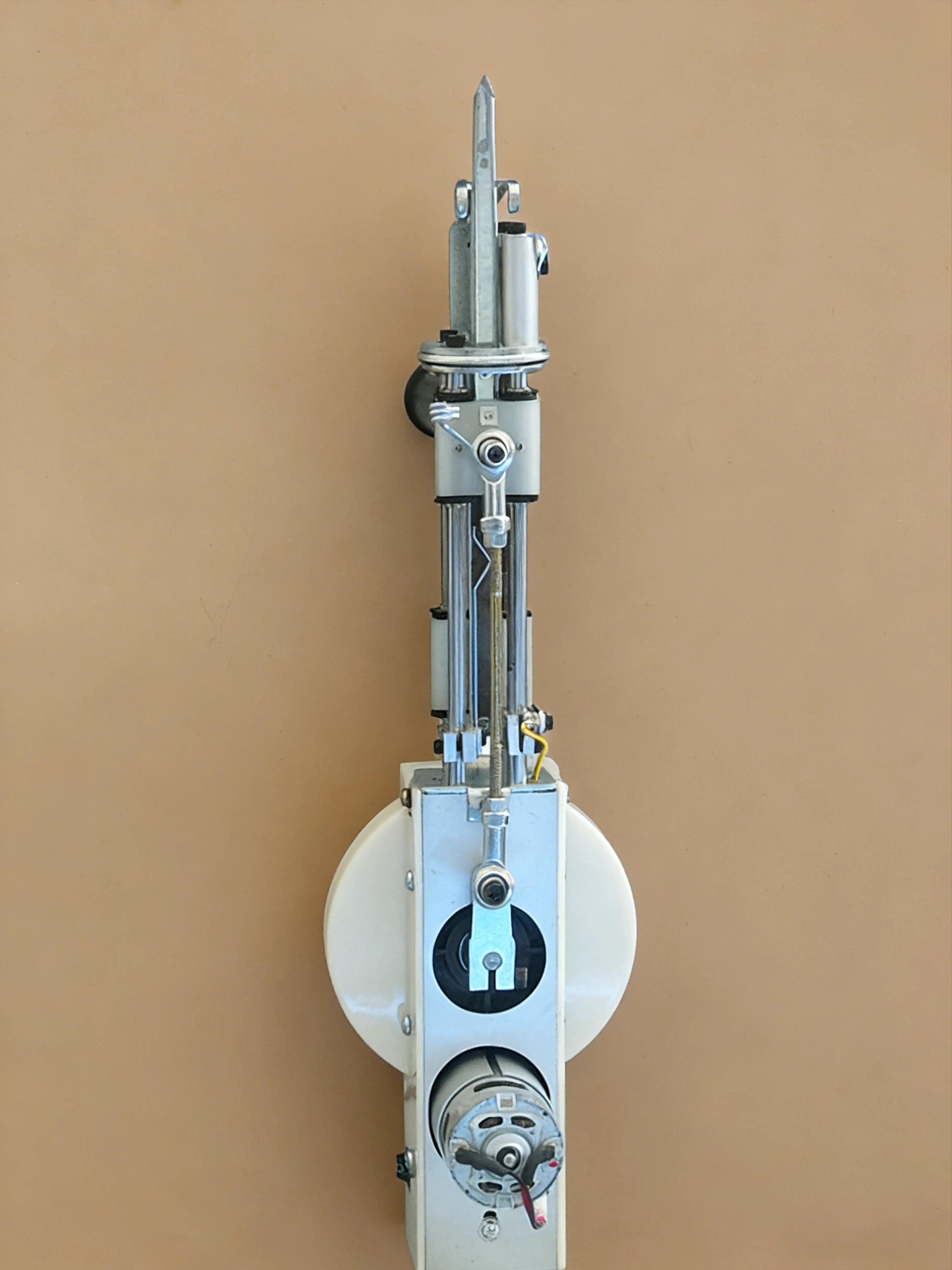 Bottom view of a long pile tufting gun showing the underside needle mechanism, yarn channel, metal base structure, and extended-pile components for high-pile rug tufting.