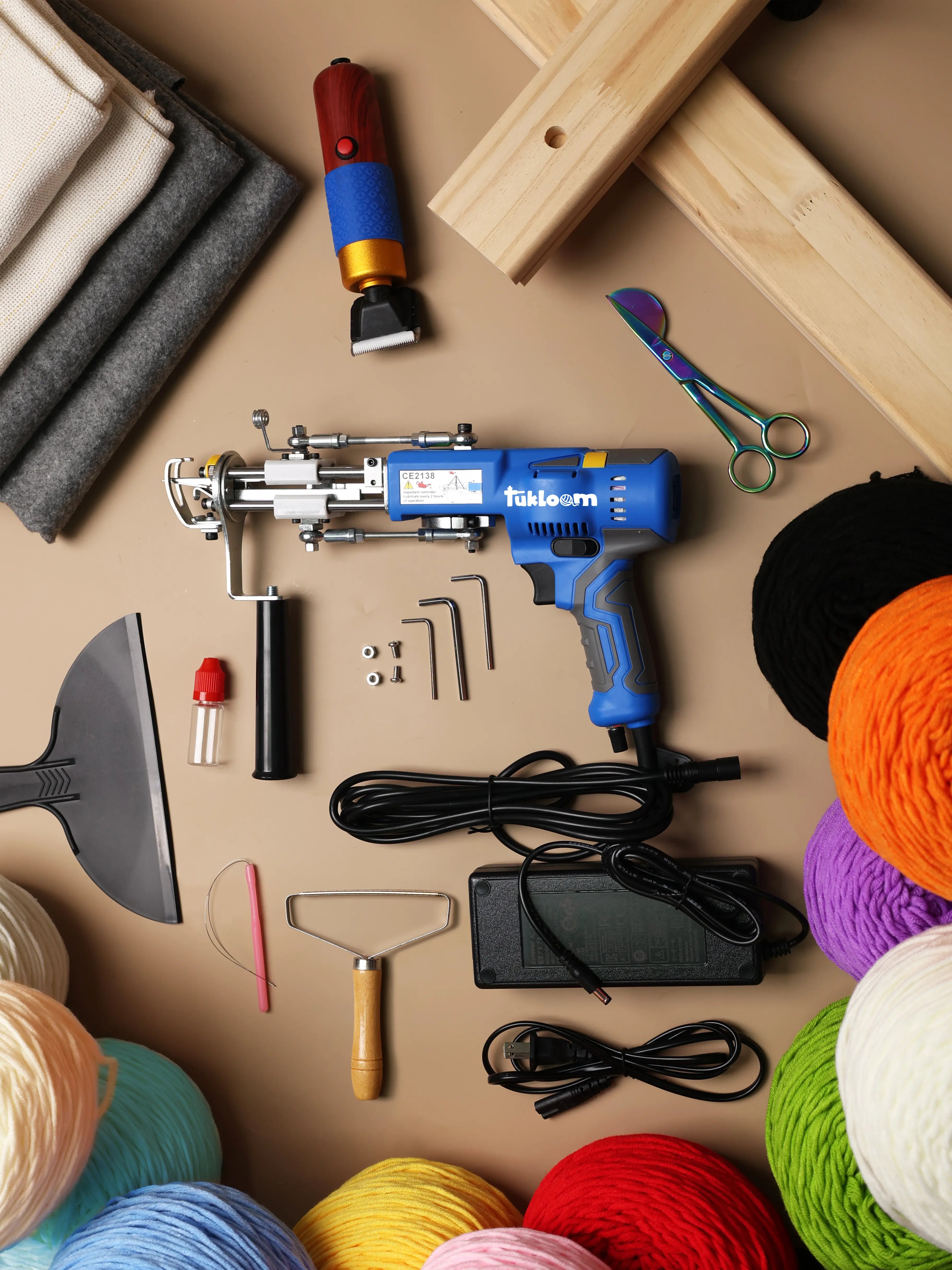 Complete AK-V tufting kit with gun, frame, dual backing fabrics, electric trimmer, scissors, and yarn cones for professional rug studios